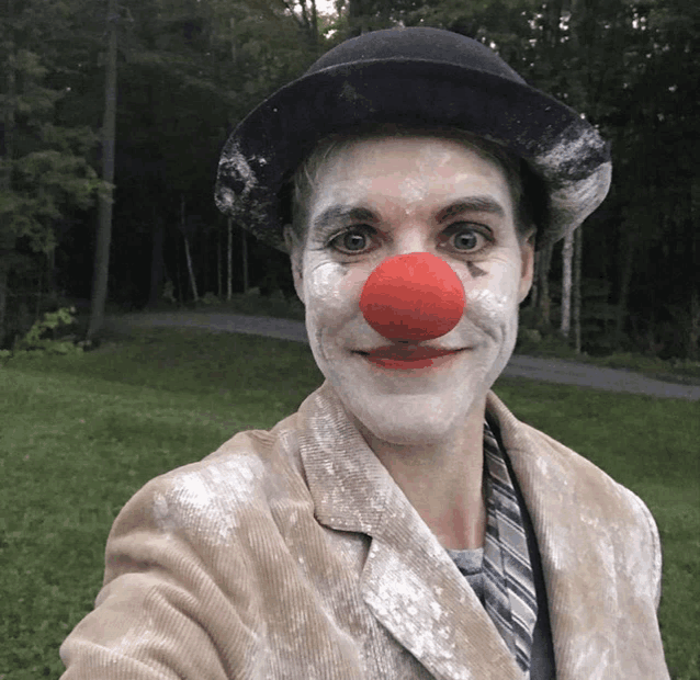 a man dressed as a clown with a red nose