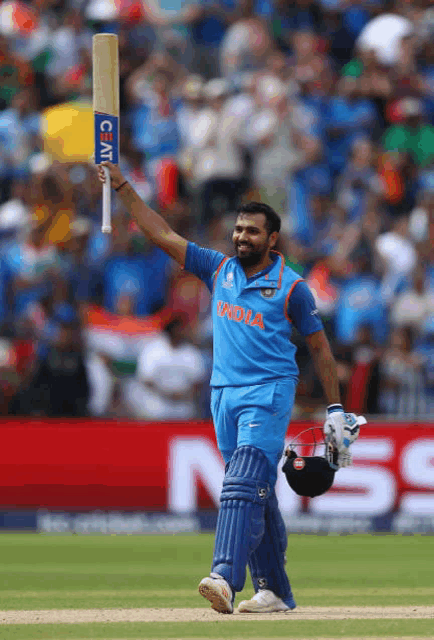 a man in a blue india jersey holds up a bat