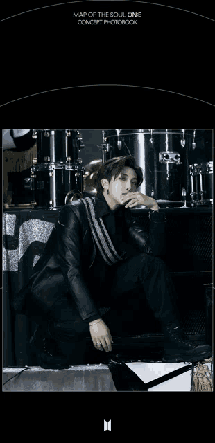 a man is kneeling in front of a drum set with the words map of the soul one concept photobook written above him