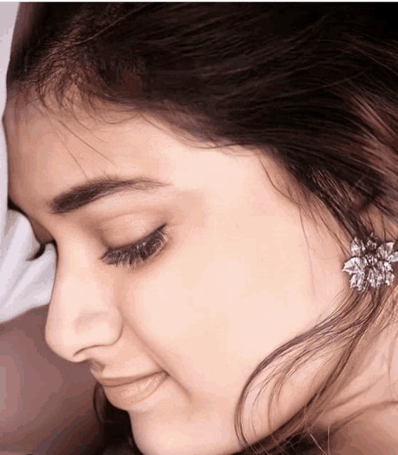 a close up of a woman 's face with earrings on her ear