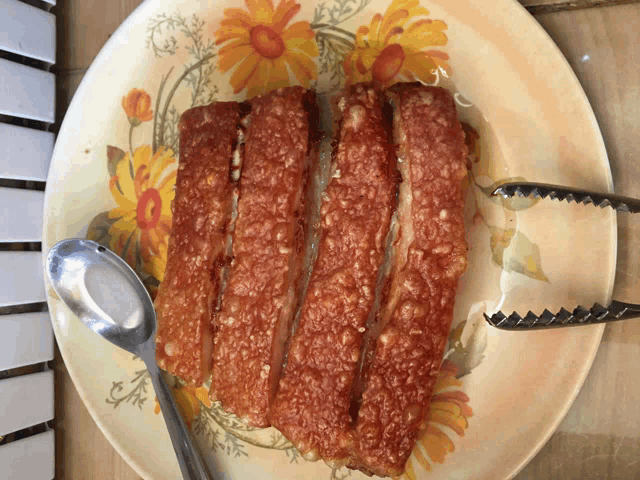 a plate of food with a spoon and tongs