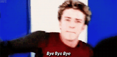 a man in a red shirt is standing in front of a blue and white wall and saying bye bye bye .