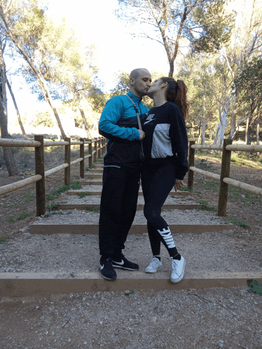 a man and a woman kissing on a set of stairs