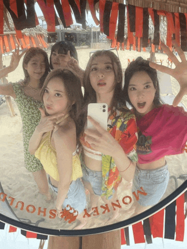 a group of girls are posing for a photo in front of a mirror that says monkey shout