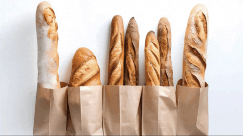 a row of bread sticks in brown paper bags