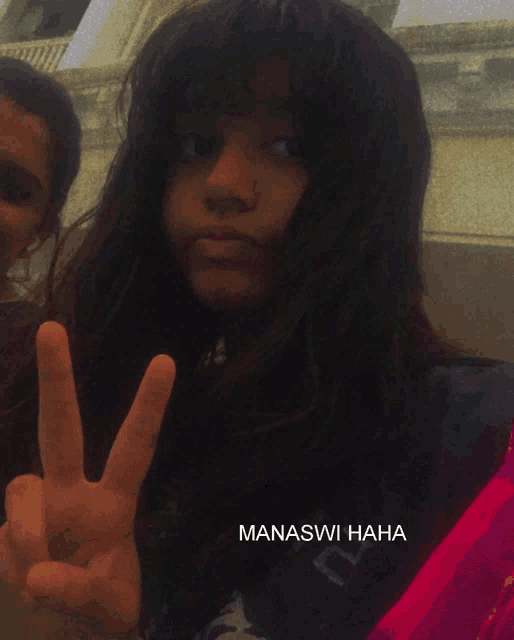 a girl giving a peace sign with manaswi haha written on the bottom