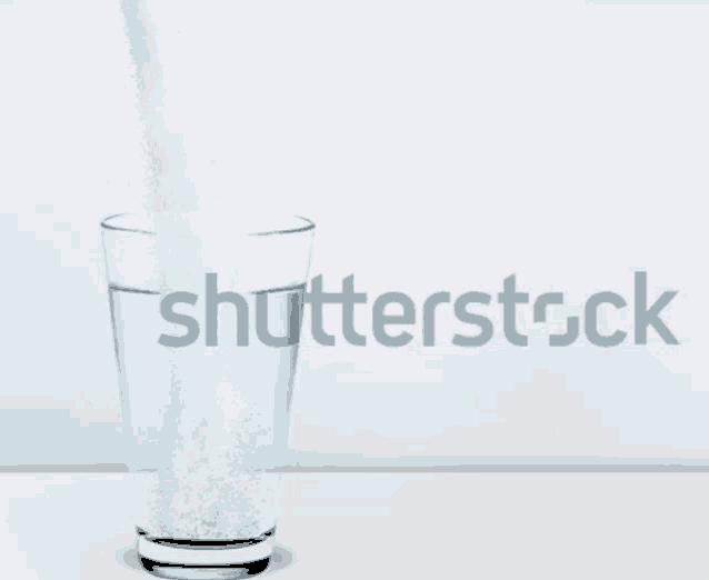 a glass of water is being poured with the word shutterstock in the background