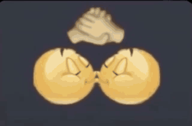 two smiley faces are kissing with a hand covering their faces