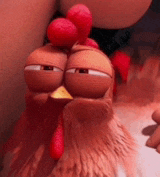 a close up of a cartoon chicken with its eyes closed and a red crest on its head .