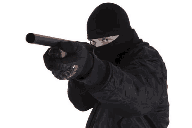 a man wearing a mask is pointing a shotgun at the camera