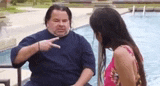 a man and a woman are sitting next to a swimming pool .