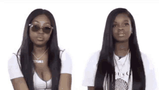 two women with long hair and sunglasses are standing next to each other on a white background .