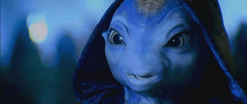 a close up of a blue alien with a hood