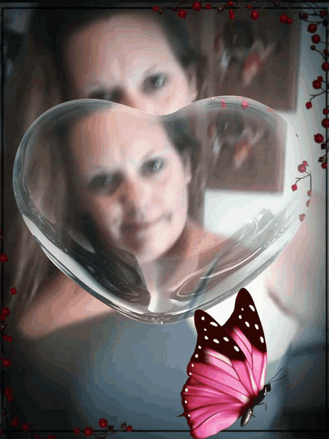 a woman is reflected in a heart shaped glass container