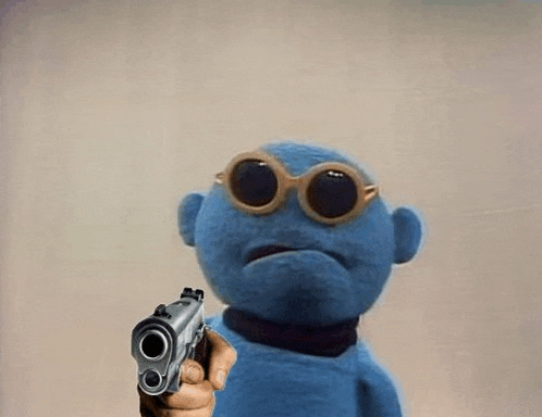 a blue stuffed animal wearing sunglasses is pointing a gun .