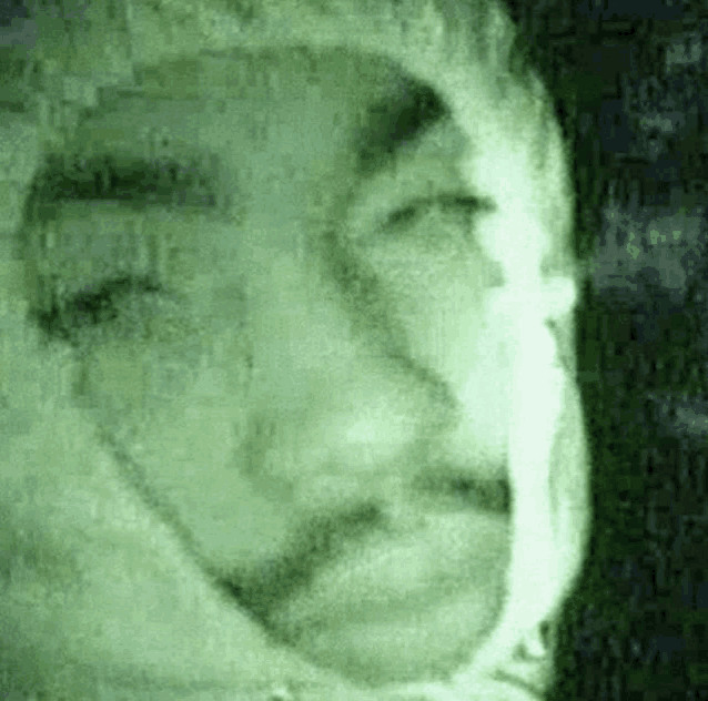 a close up of a person 's face in a green light .