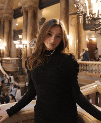 a woman in a black sweater is posing for a picture