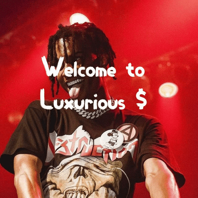 a man with dreadlocks is wearing a black shirt that says welcome to luxurious on it