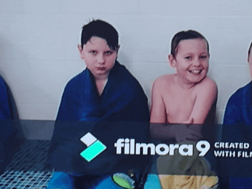 a group of young boys are wrapped in blue blankets and smiling in front of a filmora 9 logo