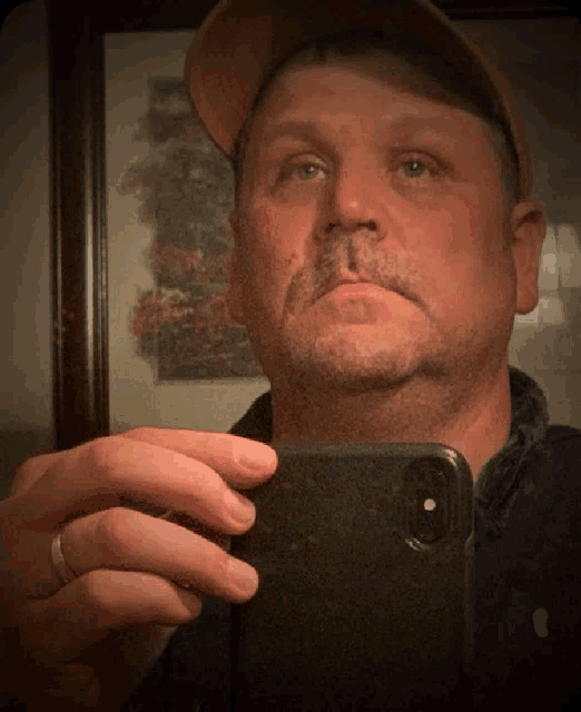 a man taking a picture of himself with his cell phone