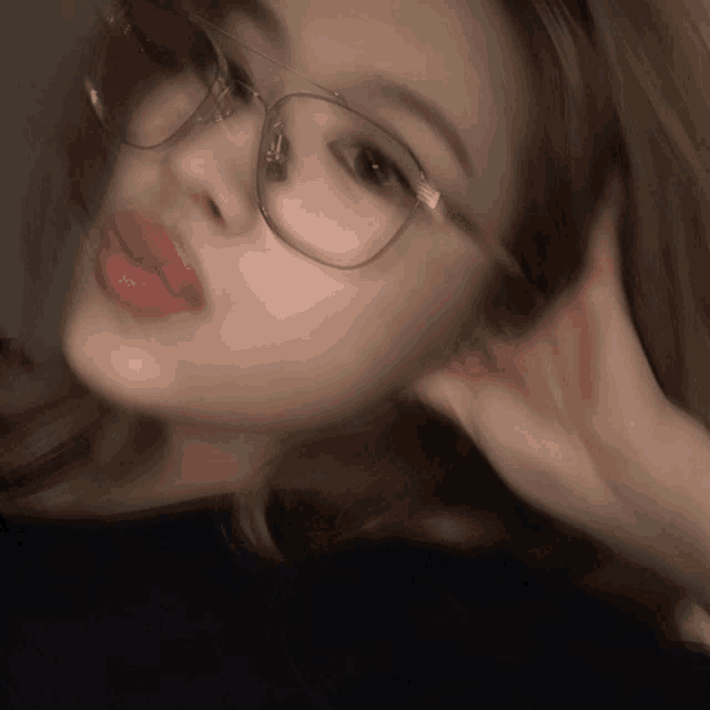 a blurry picture of a woman wearing glasses and red lips