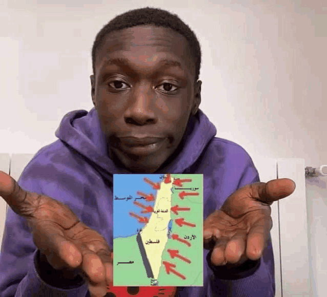 a man in a purple hoodie is holding a map of the middle east