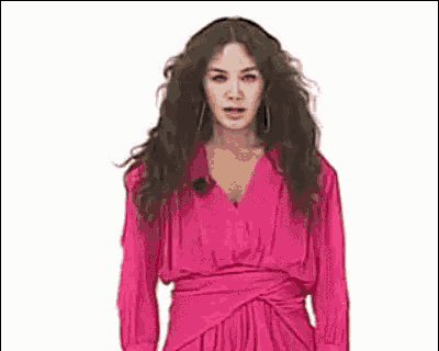 a woman in a pink dress is spinning her hair .