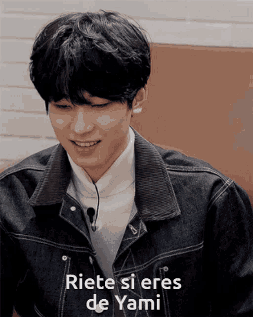 a young man in a denim jacket is smiling with the words riete si eres de yami below him