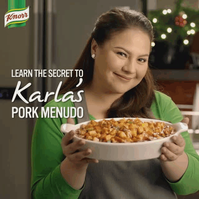 a woman is holding a bowl of food in front of a knorr bottle