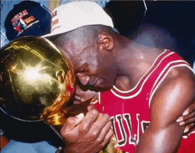 a man in a bulls jersey holds a trophy in his hands