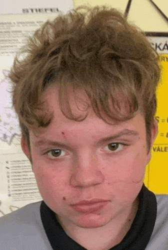 a close up of a young man 's face with a serious look on his face .