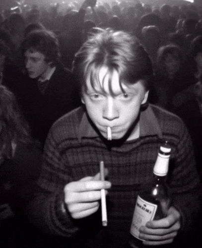 a man smoking a cigarette while holding a bottle of whiskey in front of a crowd