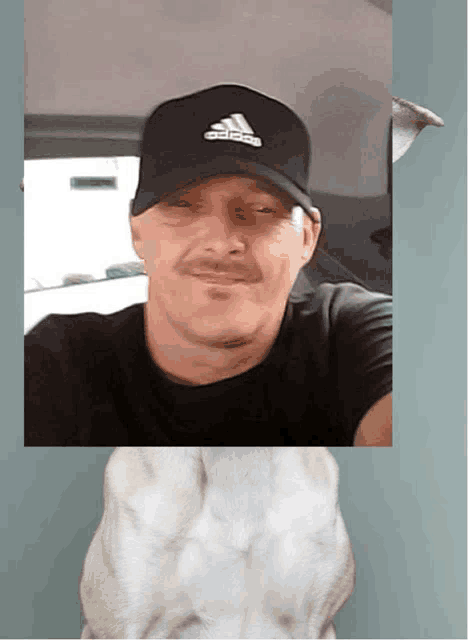 a man wearing an adidas hat takes a picture of himself