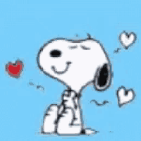 snoopy is sitting on the ground with his eyes closed surrounded by hearts .