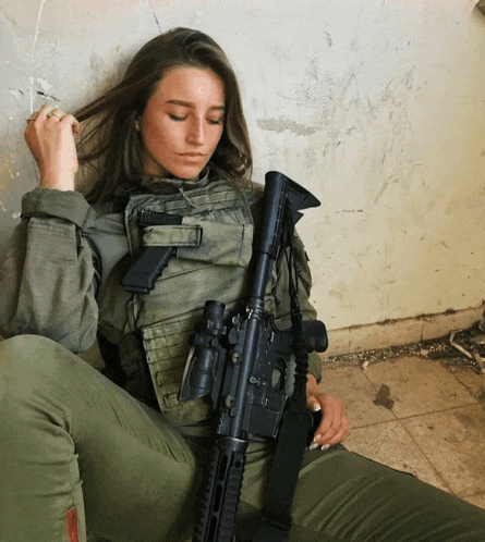 a woman in a military uniform holds a gun with the number 41 on the barrel