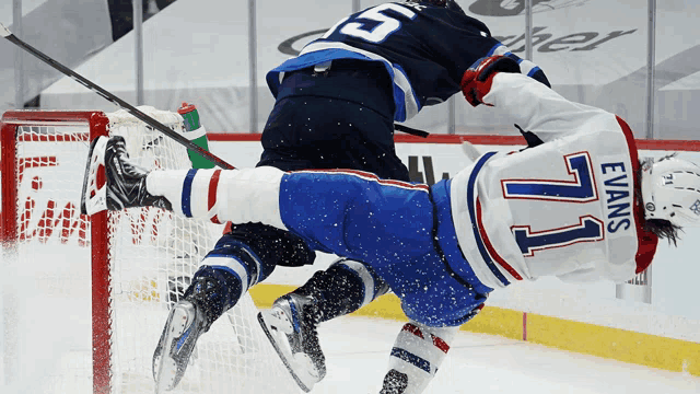 a hockey player with the number 77 on his jersey is falling to the ground