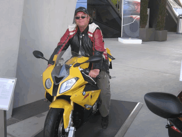 a man is sitting on a yellow motorcycle with the word bmw on the front