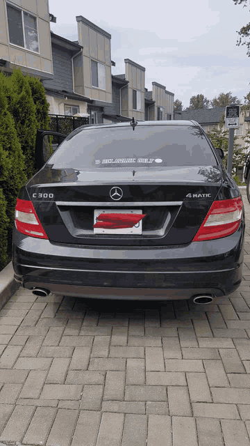 a black mercedes is parked in a parking lot