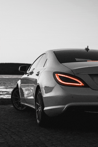 a silver mercedes with a red tail light