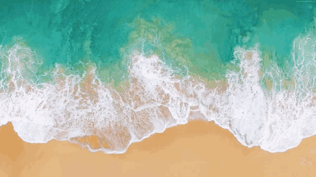 an aerial view of a beach with waves crashing on the sand