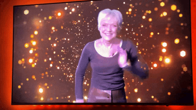 a woman dancing on a television screen with a red background