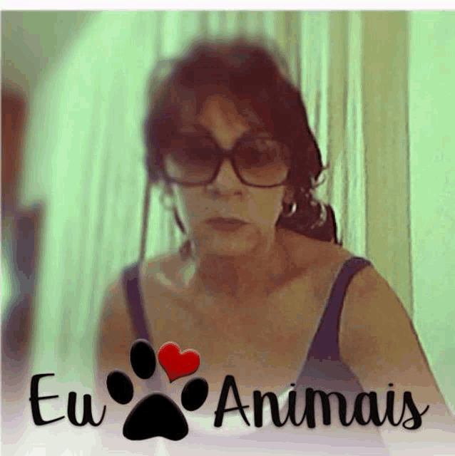 a woman wearing sunglasses and a blue tank top with eu animais written on the bottom