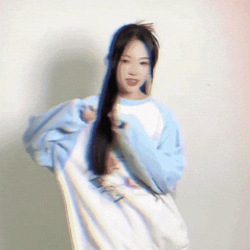 a woman with long black hair is wearing a blue and white sweatshirt