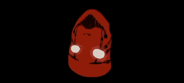 a close up of a red object with glowing eyes in the dark