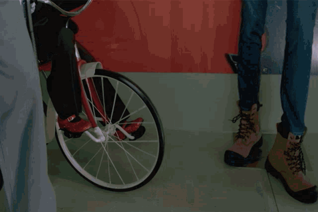 a puppet is riding a bike next to a woman 's jeans