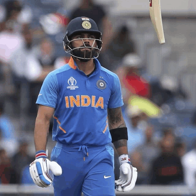 a cricket player wearing a blue shirt that says india on it