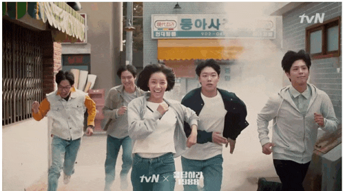 a group of people are running down a street with a tvn logo in the corner