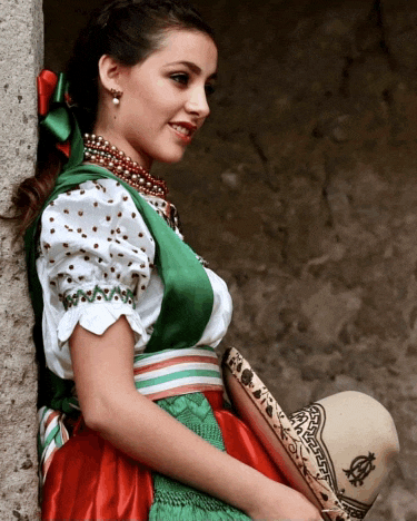 a woman leaning against a wall wearing a green white and red outfit