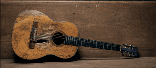 a guitar is sitting on a wooden bench with graffiti on it including one that says ' i love you ' on it