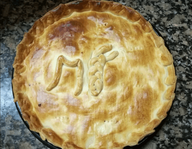 a pie with a braided letter m on top of it